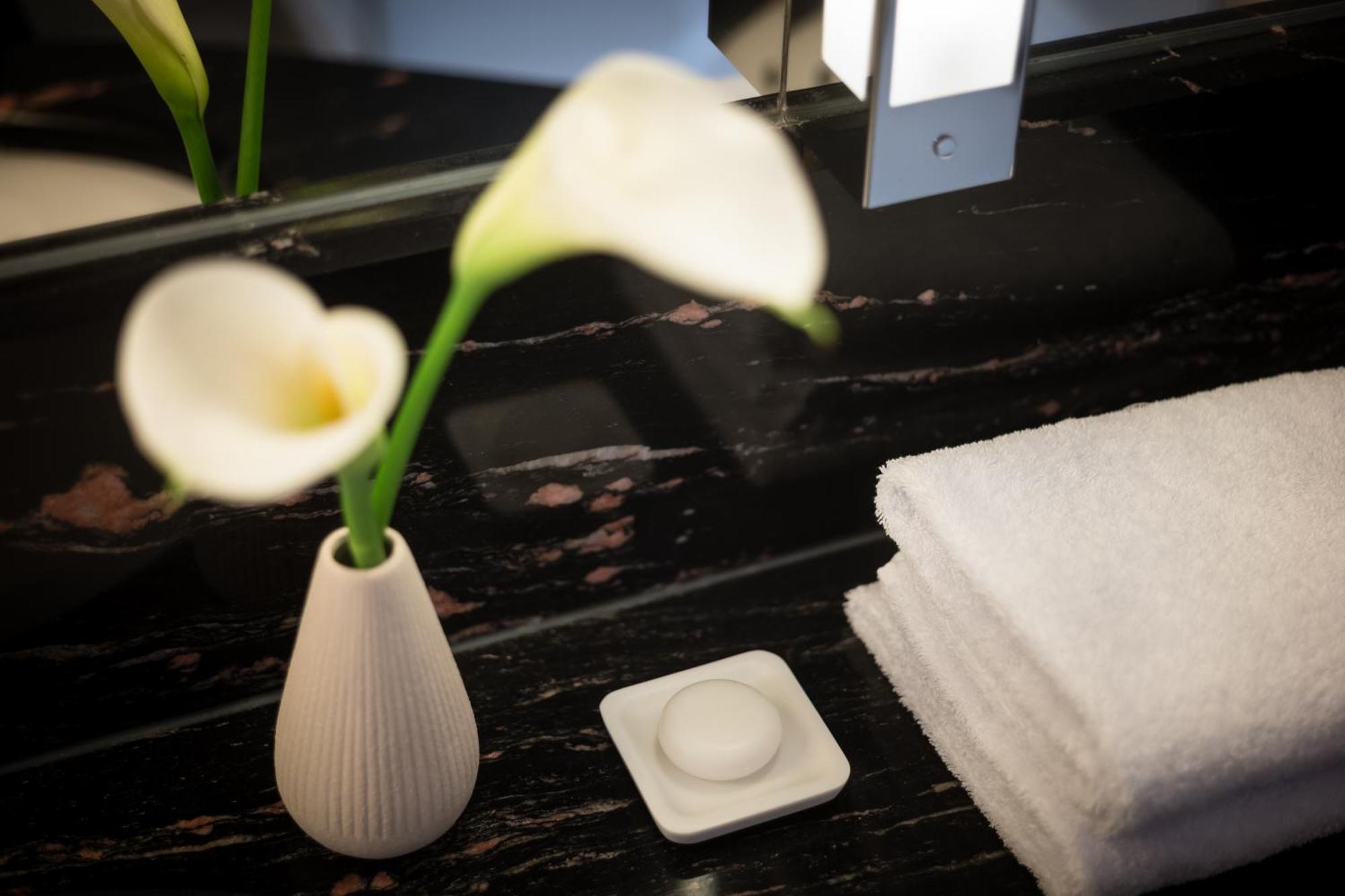 Grand Elysee Hamburg Exterior photo A small vase of flowers in a hotel room